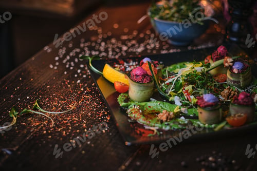 Preview: Haute cuisine vegetarian plate of appetizer rolls and a bowl of herbs served on a wooden table