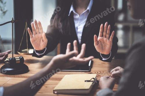 Preview: Business people and lawyers discussing contract papers with brass scale on wooden desk in office