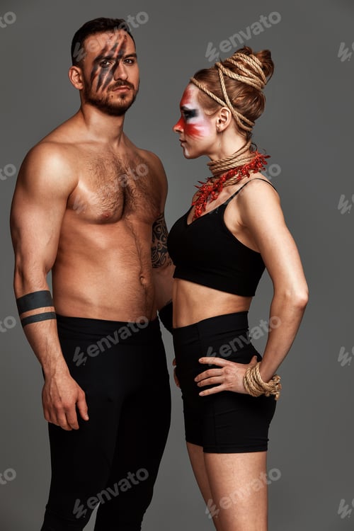 Preview: Beautiful young acrobats or gymnasts with colorful face painting on pink blue gradient background