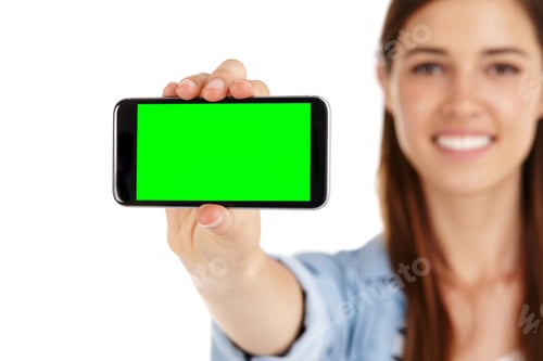 Preview: A young woman holding a mobile phone with green screen copyspace
