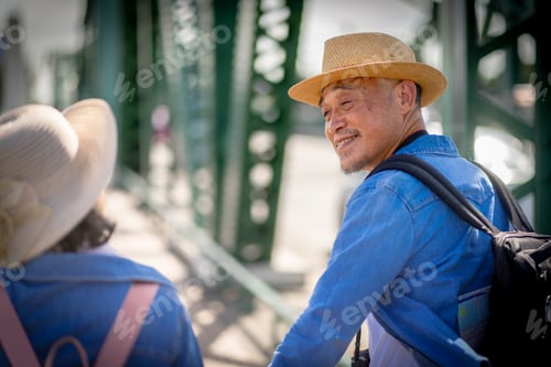 Preview: Asian retired couple happily hang out together in city full buildings in capital Thailand Bangkok