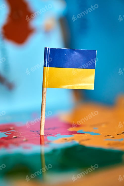 Preview: Closeup of a flag of Ukraine with a small stick on the map