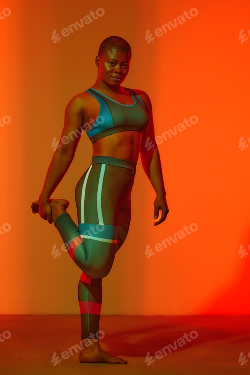Preview: Happy african american woman wearing sportive clothes showing plus size hips. Body positive concept