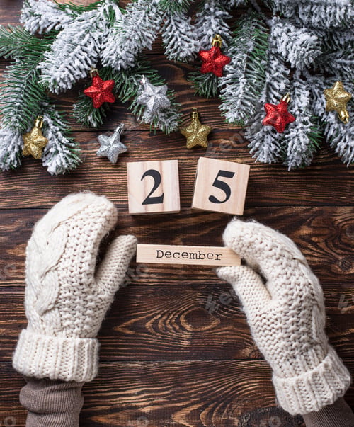 Preview: Hands in mittens holding wooden calendar