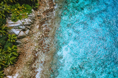 Preview: Aerial drone view of tropical coastline, crystal clear turquoise ocean water, bizarre granite rocks