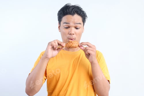 Preview: Closeup of Excited Young Man Eating Fried Chicken
