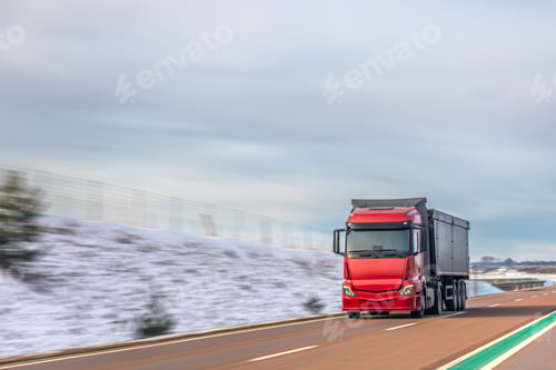 Preview: Red cargo truck driving on winter highway through snowy landscape. Freight transport logistics.