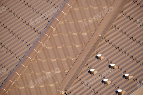 Preview: Closeup snow guard for safety in winter on house roof top covered with steel shingles.