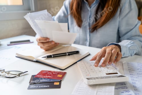 Preview: Stressed young woman calculating monthly home expenses