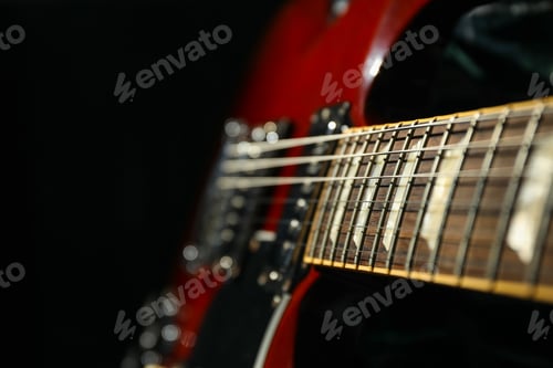 Preview: Beautiful six - string electric guitar against dark background, closeup