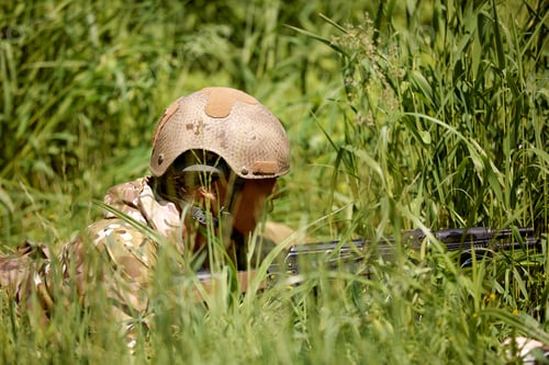 Preview: Portrait of fit military female holding weapon rifle in hands in river, posing alone. Confident