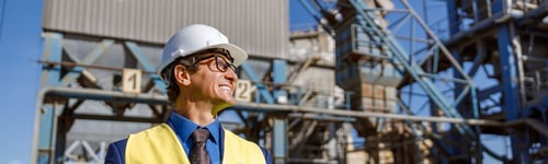 Preview: Cheerful male engineer using notebook outdoors at factory