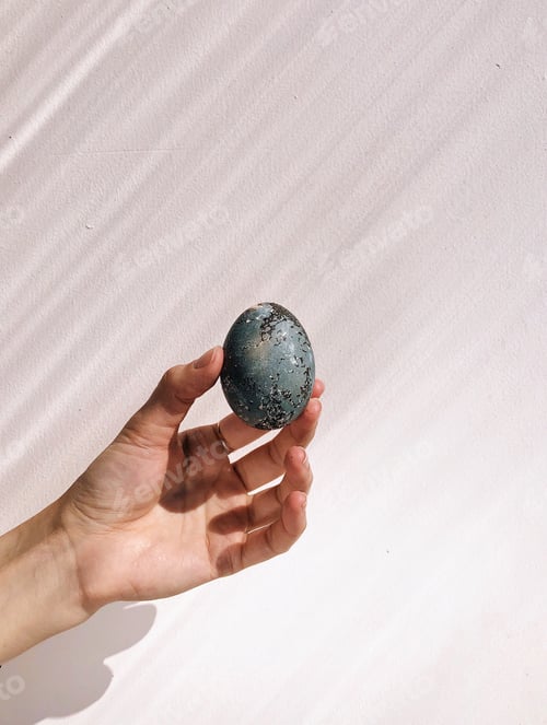 Preview: Female hand holding natural painted egg