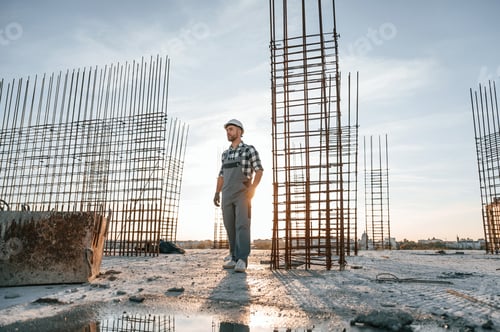 Preview: Standing in a beautiful sunlight. Man is working on the construction site at daytime
