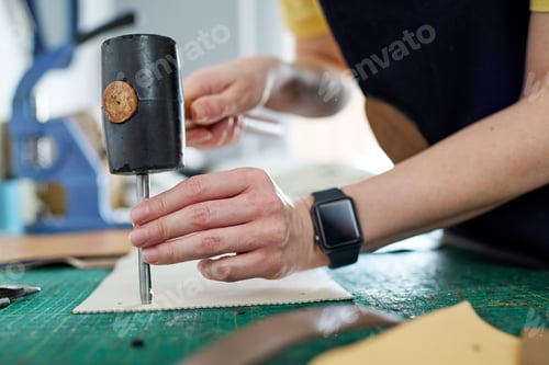 Preview: Professional female tanner pressing steel shaft down leather piece
