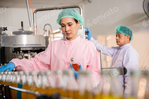 Preview: QC engineers inspect fruit juice drink production in glass bottles at the factory
