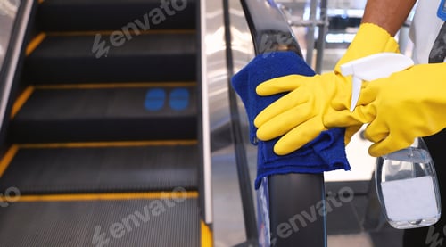 Preview: Staff cleaning the escalator hand rail in department store to prevent the pandemic Coronavirus