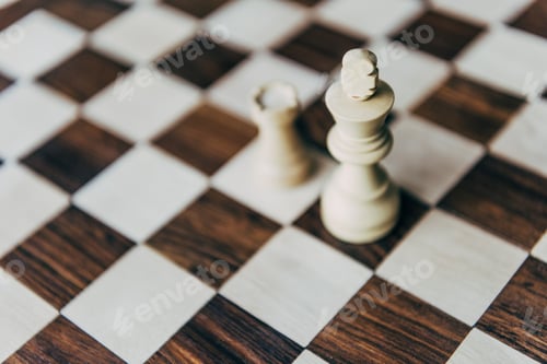Preview: Detail view of white chess king and castle figures on chess board
