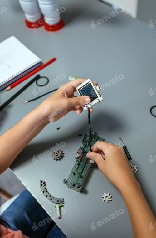 Preview: Female student connecting solar panel to electrical circuit in a robotics class