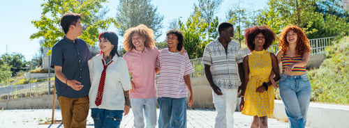 Preview: Multiethnic group of young friends meeting and having fun outdoors
