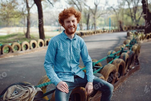 Preview: Outdoor portrait of young handsome smiling ginger man
