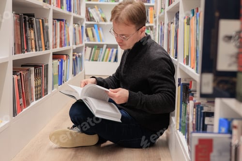 Preview: young male student in a reading room or coworking. I read books on psychology and mental health