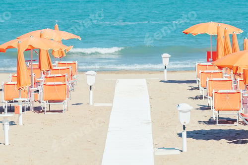 Preview: Sunbeds and parasols on the seashore. Beach, sea and umbrellas on summer day. Adriatic coast, Rimini