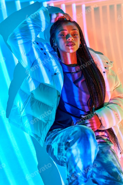 Preview: Cool young African American female model leaning on wall in studio
