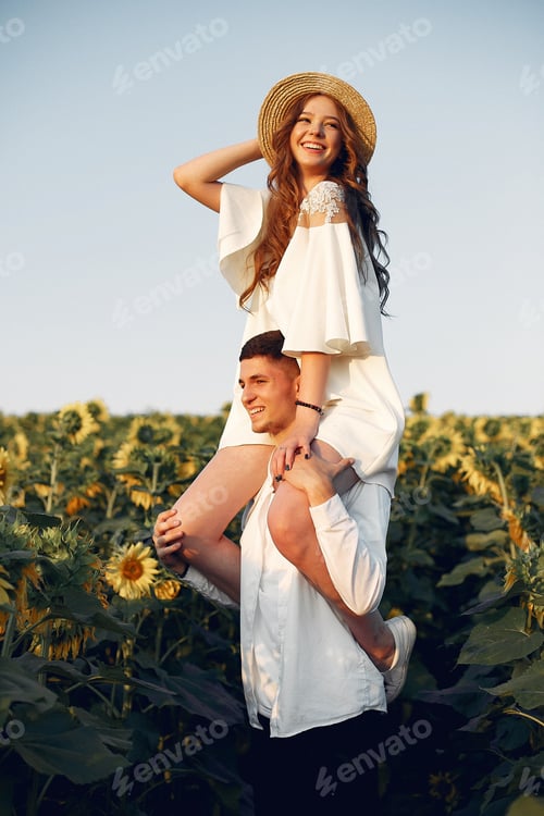Preview: Beautiful and stylish couple in a field wirh sunflowers