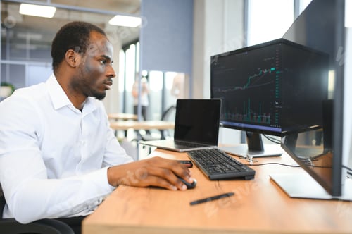 Preview: African-American broker works in office using workstation and analysis technology