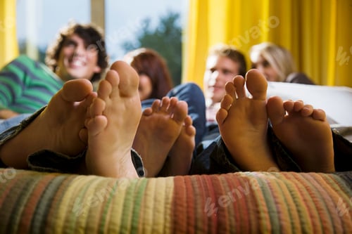Preview: Friends lounging together with feet up.