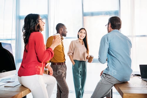 Preview: interracial business colleagues having conversation during coffee break in office