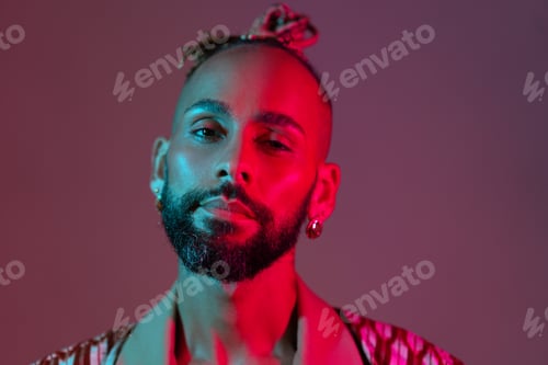 Preview: Neon light studio close-up portrait handsome black gay man looking camera.