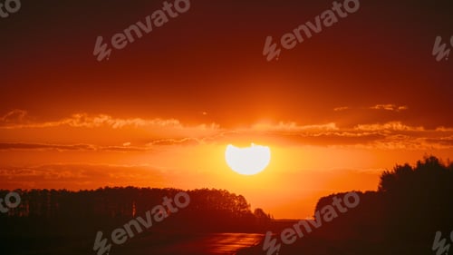 Preview: Big Sun in Vivid Beautiful Sunset Sunshine Above Summer Landscape Counrty Road And Forest. Sunset