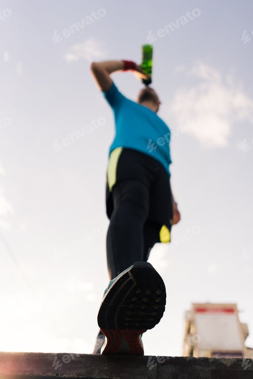 Preview: Runner drinking water during a break in the city