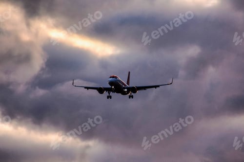 Preview: Low angle shot of an airplane descending from a clouded sky