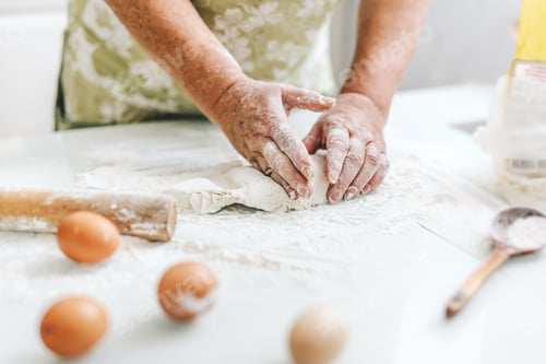 Preview: Woman kneading dough at home kitchen