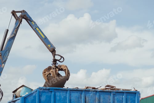 Preview: Crane-loading scrap grabber old metal at industrial metal recycling plant