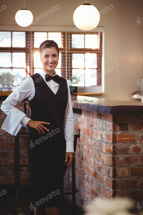 Preview: Woman bartender leaning on brick counter inside bar café, smiling beside pendant lamps, copy space