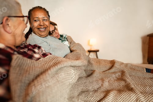 Preview: Multiracial friends having fun in front of cozy fireplace at home