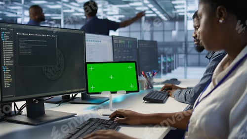 Preview: Close up of coworkers coding on chroma key device in data center