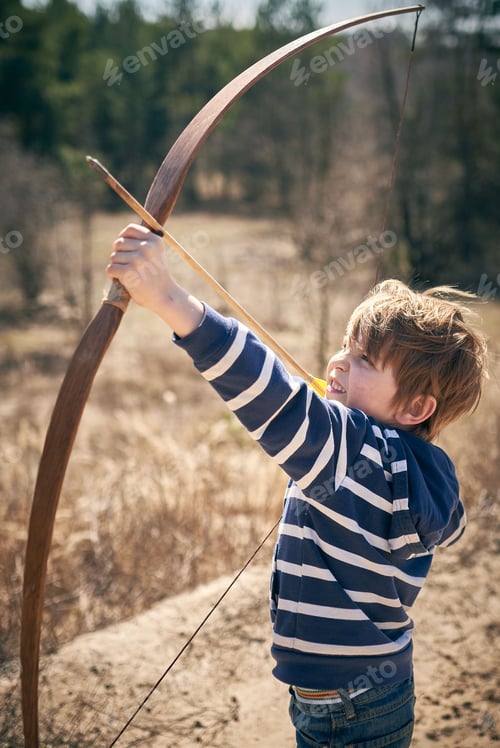 Visualização: Menino de 6 anos atira um arco ao ar livre