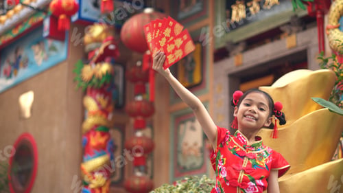 Preview: Asian girl wearing red traditional Chinese cheongsam decoration holding red envelopes in hand
