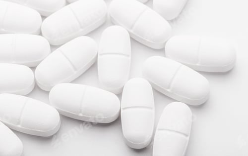 White Pills Scattered on a White Background
