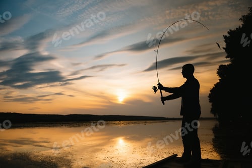 Preview: A fisherman silhouette fishing at sunset. Freshwater fishing, catch of fish.