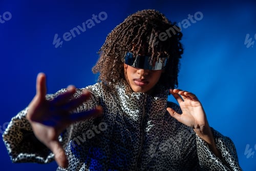 Preview: Stylish woman wearing futuristic visor posing on blue background