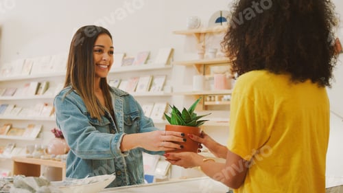 Preview: Female Customer Buying Plant From Sales Assistant In Independent Gift Store