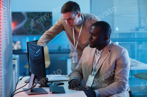 Preview: Two people looking at surveillance camera footage in security center