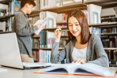 Preview: High school or college students studying and reading together in library. Student use laptop at libr
