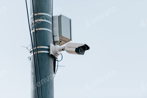 Preview: close up view of security camera on street pole with blue sky on background